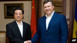 ປະທານາທິບໍດີ Viktor Yanukovich , ເບື້ອງຂວາ, ຈັບມືກັບ ປະທານປະເທດຈີນ ທ່ານຫູຈິນເຖົາ ໃນການພົບປະກັນທີ່ເມືອງ Foros, ໃກ້ກັບເມືອງ Yalta,
ວັນທີ 18 ມິຖຸນາ, 2011.