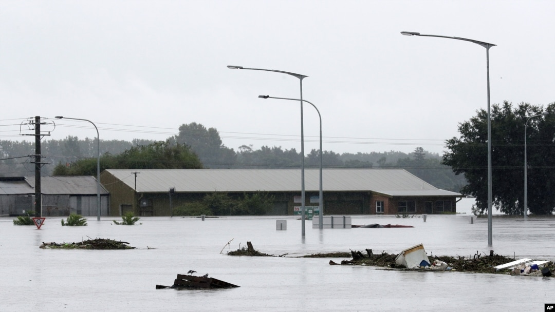 Debris floats past a partially submerged business flooded by water from the Hawkesbury River in Windsor, northwest of Sydney, New South Wales, Australia, March 22, 2021.