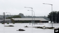 Debris floats past a partially submerged business flooded by water from the Hawkesbury River in Windsor, northwest of Sydney, New South Wales, Australia, March 22, 2021.
