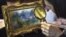 An art shopper looks closely at a 5.5 inch by 6.6 inch painting by French Impressionist master Pierre-Auguste Renoir in Alexandria, Virginia, September 25, 2012. 