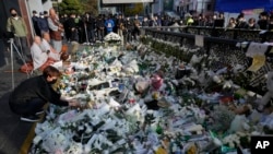 Una mujer coloca flores a las víctimas de la estampida de Halloween en Seúl, Corea del Sur, el 1 de noviembre de 2022.