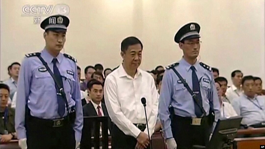 Mantan politisi China, Bo Xilai (tengah) diapit polisi saat menjalani sidang di pengadilan Jinan, propinsi Shandong, China (22/8).