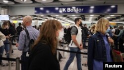 FILE - Arriving passengers queue at UK Border Control at Terminal 5 at Heathrow Airport in London, Britain, June 29, 2021.