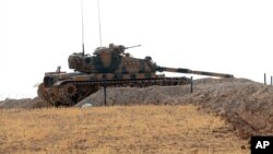 FILE - A Turkish tank is stationed near the Syrian border, in Karkamis, Turkey, Aug. 29, 2016. 