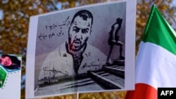 استنبول میں ایرانی گلوکار توماج صالحی کی گرفتاری کے خلاف ایک مظاہرے میں شامل ایک شخص نے صالحی کی تصویر اٹھا رکھی ہے۔ 
