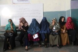 Afghan women wait for a polling station to open in Kabul, Afghanistan, Sept. 28, 2019. Afghans headed to the polls to elect a new president amid high security and Taliban threats to disrupt the elections.