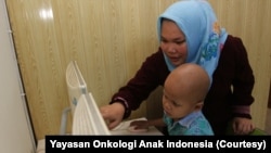 Adit, pasien kanker anak yang berasal dari Riau bermain didampingi ibunya bermain di Rumah Singgah Graha Yayasan Onkologi Anak Indonesia (YOAI). (Foto: Yayasan Onkologi Anak Indonesia)