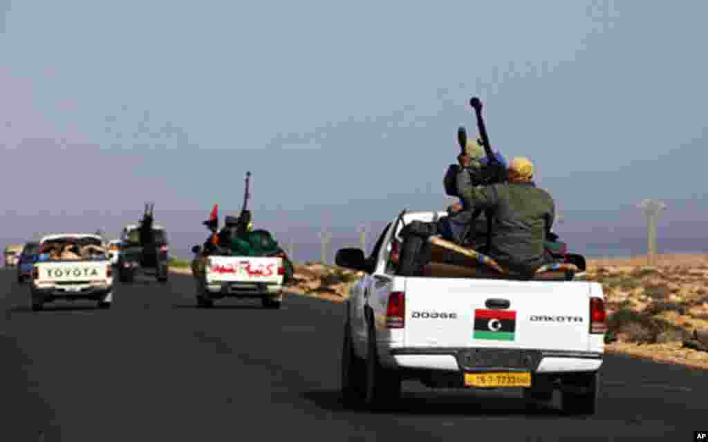 Rebels travel in a convoy on their way to Sirte city near Bin Jawad March 28, 2011. A steady stream of rebels in 4x4 pick-ups mounted with machineguns drove in the direction of Libyan leader Muammar Gaddafi's hometown of Sirte on Monday, seeking to extend