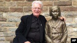 Uniting Church minister Bill Crews poses for a photo with a statue erected as a memorial to sex slaves of Japan's World War II army in Sydney, Australia, Aug 6. 2016. A Japanese-Australian community leader said Thursday he had filed a complaint of racial discrimination against the Sydney church that he alleged intimidated Japanese nationals by erecting a memorial to sex slaves of Japan's World War II army. 