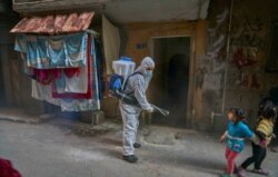 Workers disinfect densely populated neighborhoods in Cairo, March 24, 2020. (Hamada Elrasam/VOA)