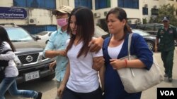 Kum Chandaraty, left, walks with her lawyer, Try Chhoun, after being questioned by the Ministry of Interior’s anti-terrorism department on Friday. (Photo: Neou Vannarin/VOA Khmer) 