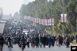 Supporters of imprisoned former Prime Minister Imran Khan's Pakistan Tehreek-e-Insaf party move toward D-Chowk square during their rally demanding Khan's release, in Islamabad on Nov. 26, 2024.