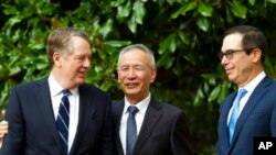 Wakil Perdana Menteri China Liu He didampingi oleh Perwakilan Dagang AS Robert Lighthizer (kiri) dan Menteri Keuangan Steven Mnuchin, menyambut media sebelum pertemuan perdagangan tingkat menteri di Washington, Kamis, 10 Oktober 2019. (Foto AP / Jose Luis Magana)