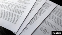 FILE - US Attorney General William Barr's signature is seen on a four-page letter to U.S. congressional leaders on the conclusions of Special Counsel Robert Mueller's report on Russian 2016 election meddling after the letter was released by the House Judi