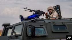 A Russian soldier mans a machine gun during a patrol near the Syria-Turkey border in north Syria, Oct. 25, 2019.