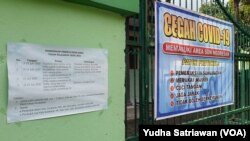 FILE - Tempelan kertas berisi jadwal Penerimaan Peserta Didik Baru (PPDB) untuk sekolah dasar negeri ditempel di pintu masuk salah satu SD Negeri di Solo, Minggu, 14 Juni 2020. (Foto: VOA/Yudha Satriawan)