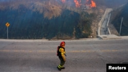 Un bombero camina mientras trabaja para extinguir un incendio forestal, en Quito, Ecuador, el 24 de septiembre de 2024. REUTERS/Karen Toro 