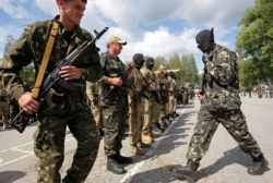 FILE - Members of the Donbass self-defense battalion attend a ceremony to swear an oath to be included in a reserve battalion of the National Guard of Ukraine near Kyiv, June 23, 2014.