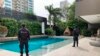In this photo distributed by Colombia's Attorney Generals Office, officials pose with their backs to the camera by a pool on a property allegedly belonging to Alex Saab in Barranquilla, Colombia, July 22, 2020.