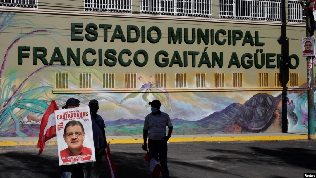 Un hombre sostiene un cartel durante el velorio de Francisco Gaitán, alcalde del municipio de Cantarranas y miembro del Partido Liberal, quien fue asesinado luego de un mitin político previo a las elecciones generales, en Cantarranas, Honduras, el 14 de noviembre de 2021.