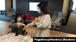 An employee has her temperature checked before entering PageGroup's office after reopening, as the coronavirus disease (COVID-19) continues, in Shanghai, China, April 29, 2020.