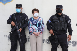La exalcaldesa de San Salvador Violeta Menjívar flanqueada por dos policías tras su arresto el 22 de julio de 2021 por acusaciones de corrupción. Foto cortesía FGR de El Salvador.