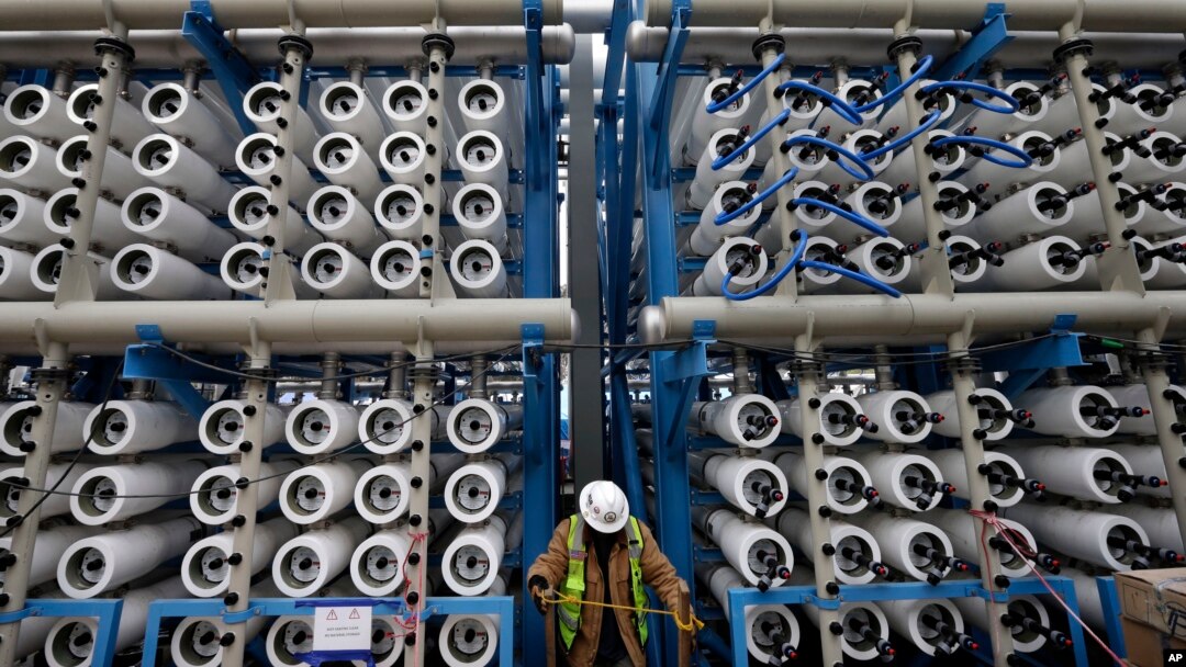 FILE - A worker climbs stairs among some of the 2,000 pressure vessels that will be used to convert seawater into fresh water through reverse osmosis in a desalination plant in Carlsbad, Calif., March 11, 2015. 