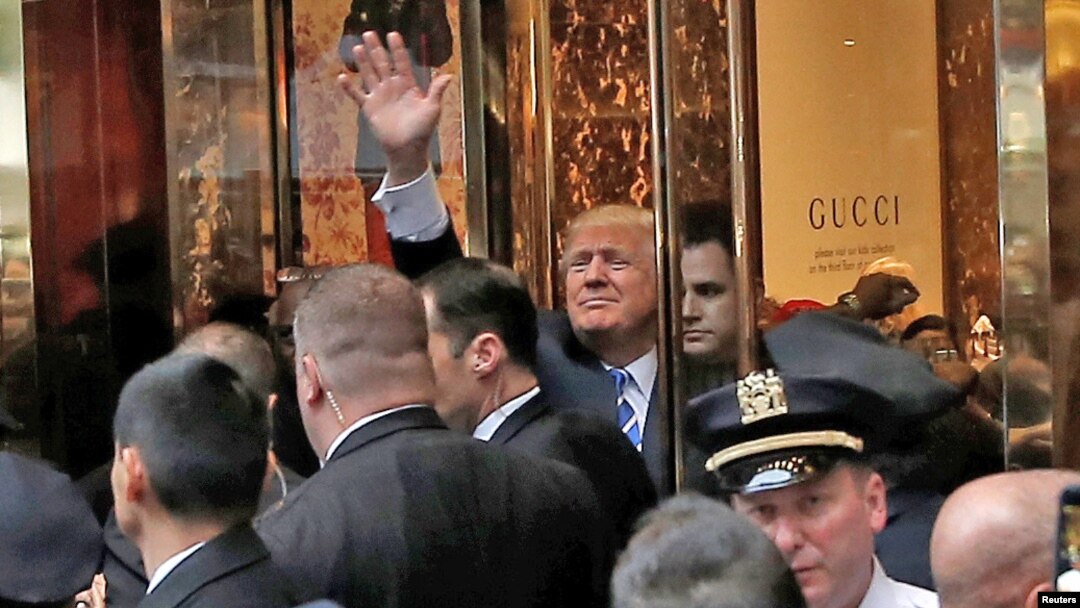 FILE - Republican presidential nominee Donald Trump waves to supporters outside the front door of Trump Tower where he lives in the Manhattan borough of New York, Oct. 8, 2016. 