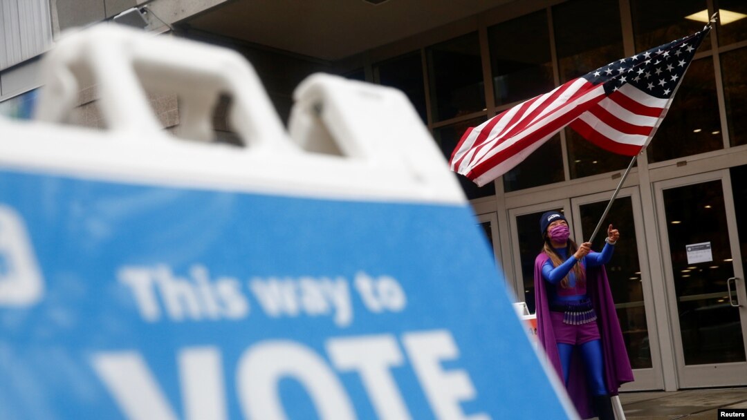 En la imagen de archivo un hombre ondea una bandera de EE. UU. para alentar a la gente a votar, fuera del Centro de Eventos de Campo de CenturyLink el día de las elecciones, en Seattle, Washington, EE. UU. El 3 de noviembre de 2020. 