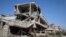 FILE - Buildings damaged during clashes between troops loyal to Libya's eastern government and the Shura Council of Libyan Revolutionaries are seen during a cleanup of the debris in Benghazi, Libya April 24, 2016.