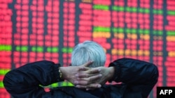 FILE - An investor looks at a screen showing stock market movements at a securities company in Hangzhou, in eastern China's Zhejiang province, February 8, 2024. Asian markets shares were mixed on Tuesday, with trading closed in Tokyo and Seoul for New Year holidays.