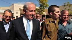 Prajurit Israel yang dibebaskan Hamas, Gilad Shalit (kedua dari kanan), bersama ayahnya, Noam Shalit (kanan) dan PM Israel Benjamin Netanyahu (18/10).