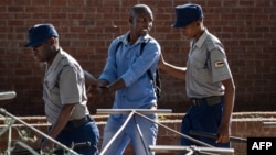 FILE:A man is arrested by police officers after resisting orders to vacate a vegetable market area in Bulawayo, Zimbabwe, March 31, 2020, on the second day of a lockdown to curb the spread of COVID-19.