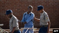 A man is arrested by police officers after resisting orders to vacate a vegetable market area in Bulawayo, Zimbabwe, March 31, 2020, on the second day of a lockdown to curb the spread of COVID-19.