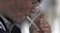 FILE - A man lights a cigarette in Los Angeles, California.