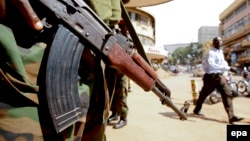 Un officier de la police ougandaise monte la garde sur une rue au centre-ville de Kampala, en Ouganda, 20 février 2011.