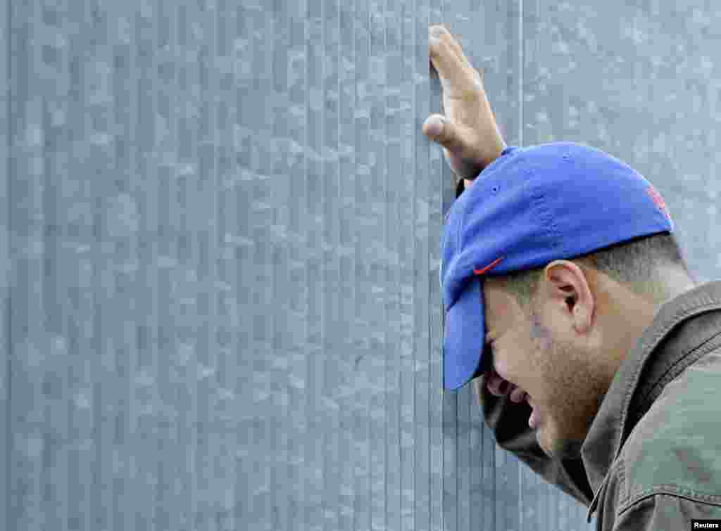 Un homme pleure à l'extérieur des ruines du World Trade Center à New York, le 11 septembre 2006. 