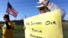 Jane Malin holds a sign as she waves to passing cars during a rally to show support for Muslim members of the community near the Clear Lake Islamic Center in Webster, Texas, Dec. 4, 2015. 