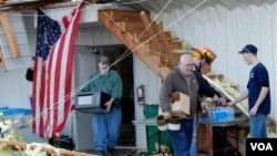 Anggota Pemadam Kebakaran Milton bekerja membersihkan sisa-sisa tornado yang menyapu kantor mereka di Milton, Kentucky (2/3)