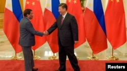 Chinese President Xi Jinping (R) shakes hands with Philippines President Rodrigo Duterte prior to their bilateral meeting during the Belt and Road Forum, at the Great Hall of the People in Beijing, China, May 15, 2017