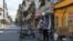 A man picks up groceries through a barrier in a quarantine area amid (COVID-19) in Hanoi.