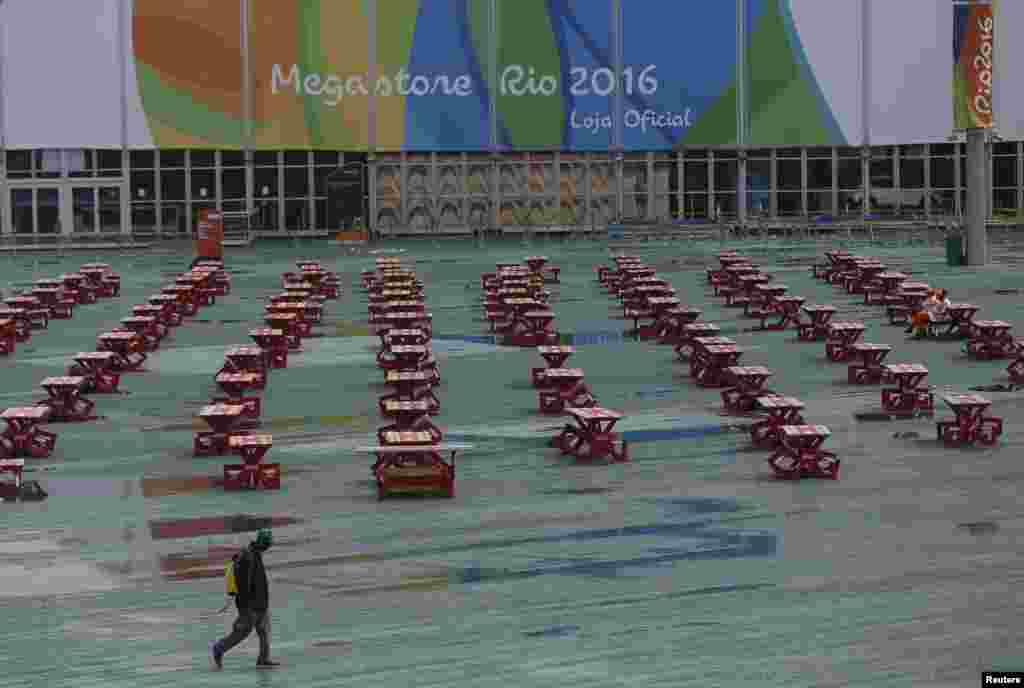 A person walks in the rain through the Olympic Park a day after the closing ceremony of the Rio 2016 Olympic Games, in Rio de Janeiro, Brazil, Aug. 22, 2016.
