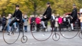 Participants wearing historical costumes ride their high-wheel bicycles during the annual penny farthing race in Prague, Czech Republic, Nov. 2, 2024, 