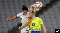United States' Carli Lloyd, left, and Sweden's Amanda Ilestedt, right, go for a header during a women's soccer match at the 2020 Summer Olympics, July 21, 2021, in Tokyo.