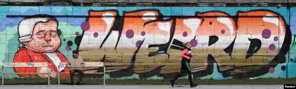 A jogger runs past graffiti on a sunny Spring day in Vienna, Austria. 