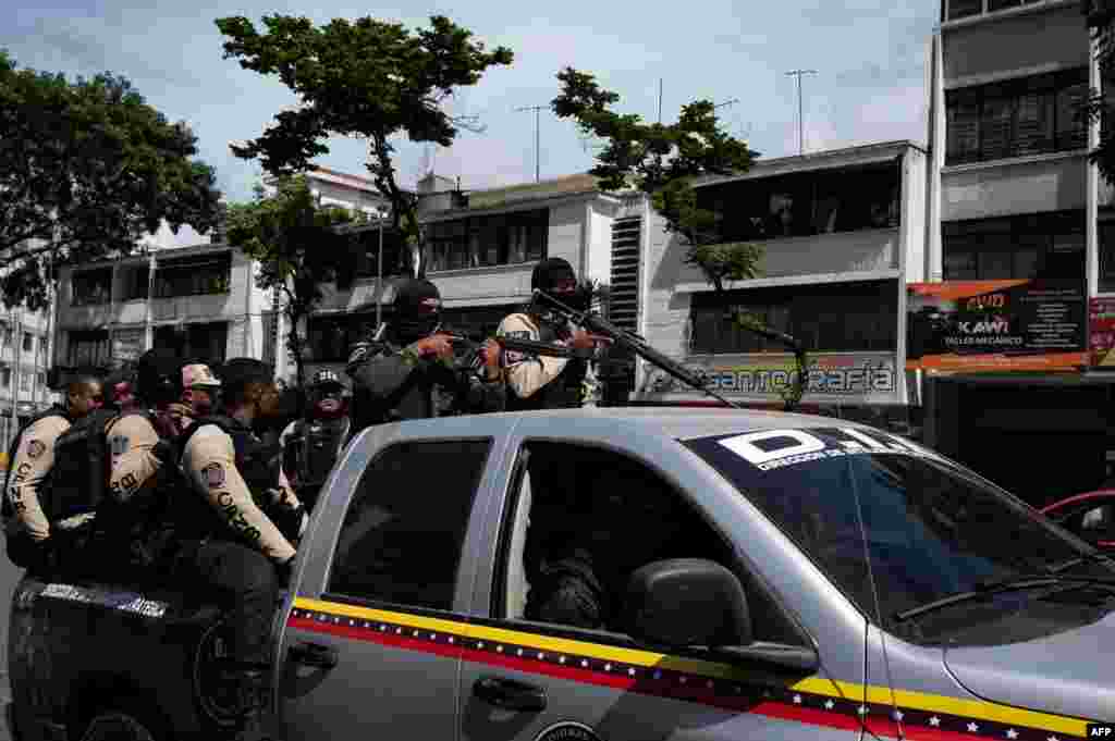 Comandos llega a una avenida de Caracas durante enfrentamientos. Juan Guaid&#243;, considerado presidente interino por decenas de pa&#237;ses, asegur&#243; que las bandas fueron armadas a&#241;os atr&#225;s por el Gobierno. Junio, 8 2021. Foto: Yuri Cortez - AFP. 