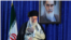 Iranian Supreme Leader Ayatollah Ali Khamenei gestures to a crowd at a June 4, 2019 ceremony in Tehran marking the 30th anniversary of the death of his predecessor, Ayatollah Ruhollah Khomeini, whose portrait appears behind him.