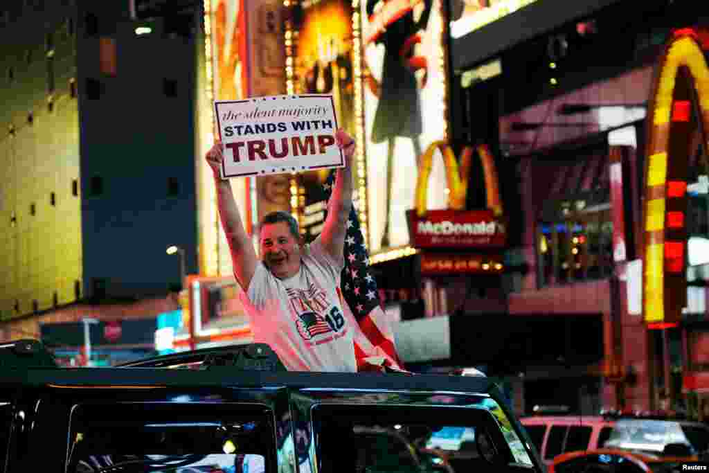 A man leans out of a Hummer shouting words in support of U.S. Republican presidential nominee Donald Trump while driving through Times Square in New York, Nov. 9, 2016.