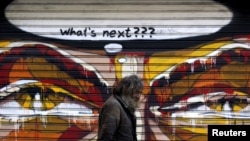 一名希腊人走过雅典一截画有图画的墙 （2015年7月14日）