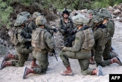 Israeli army soldiers sit kneeling at a position in the upper Galilee region of northern Israel near the border with Lebanon on Nov. 1, 2023, amid increasing cross-border tensions between Hezbollah and Israel.